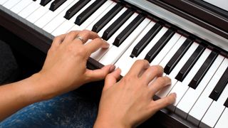 Overhead photo of hands on digital piano keys